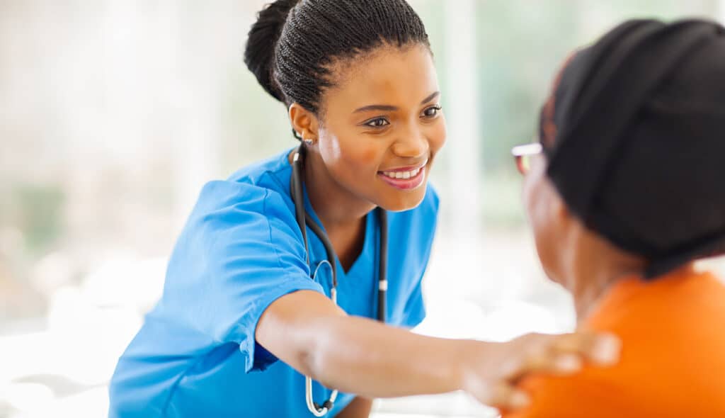 Nurse comforting senior patient in office